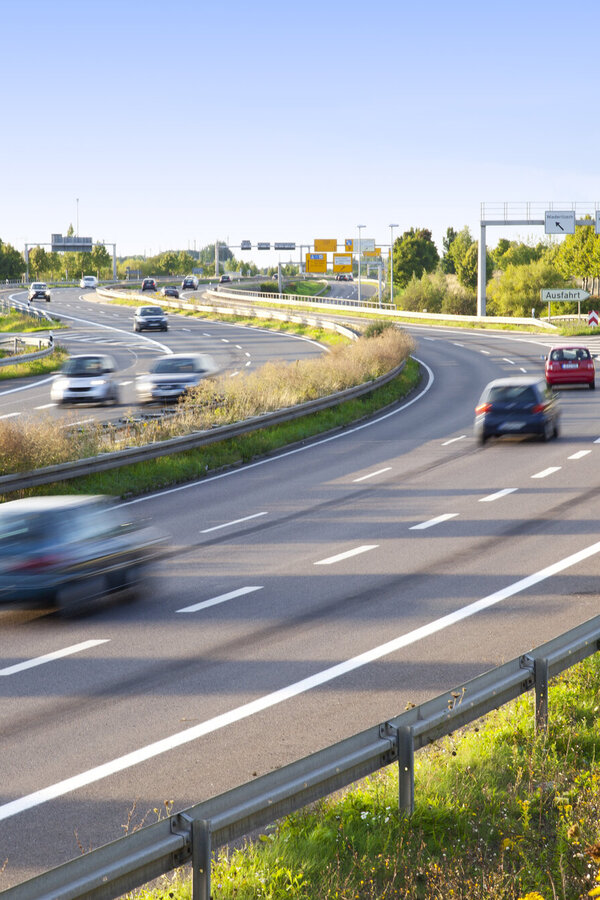 Mehrspurige Straße mit fließendem Verkehr in einer Kurve