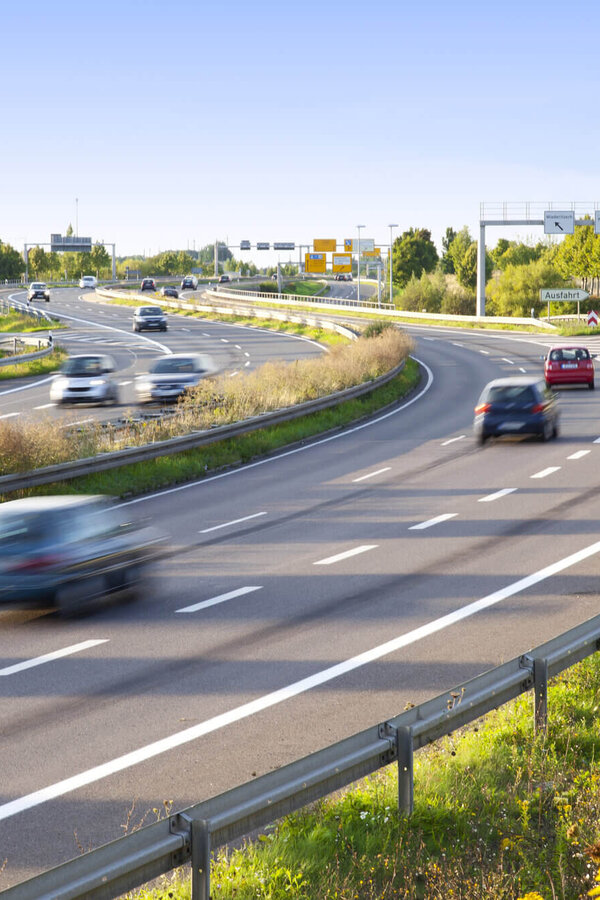 Mehrspurige Straße mit fließendem Verkehr in einer Kurve